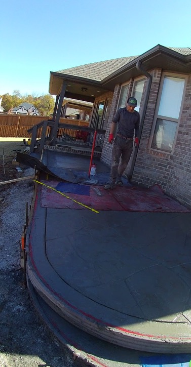 A concrete finisher working carefully along a new patio