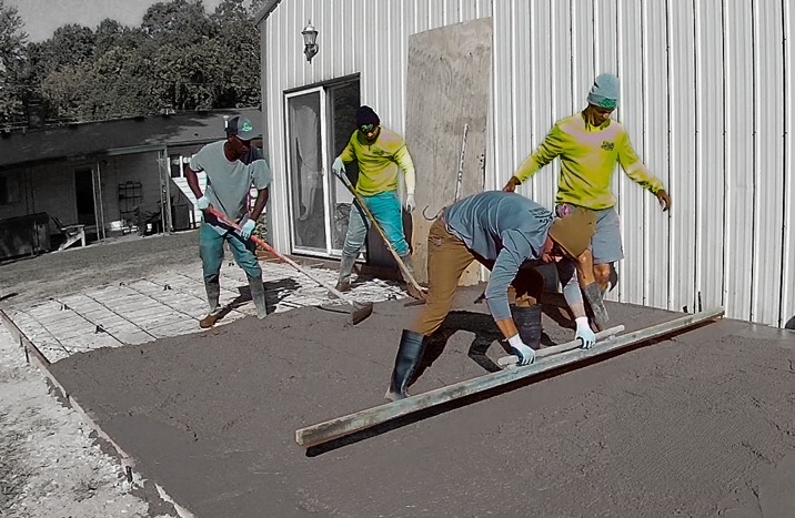 A crew screeding a fresh concrete slab