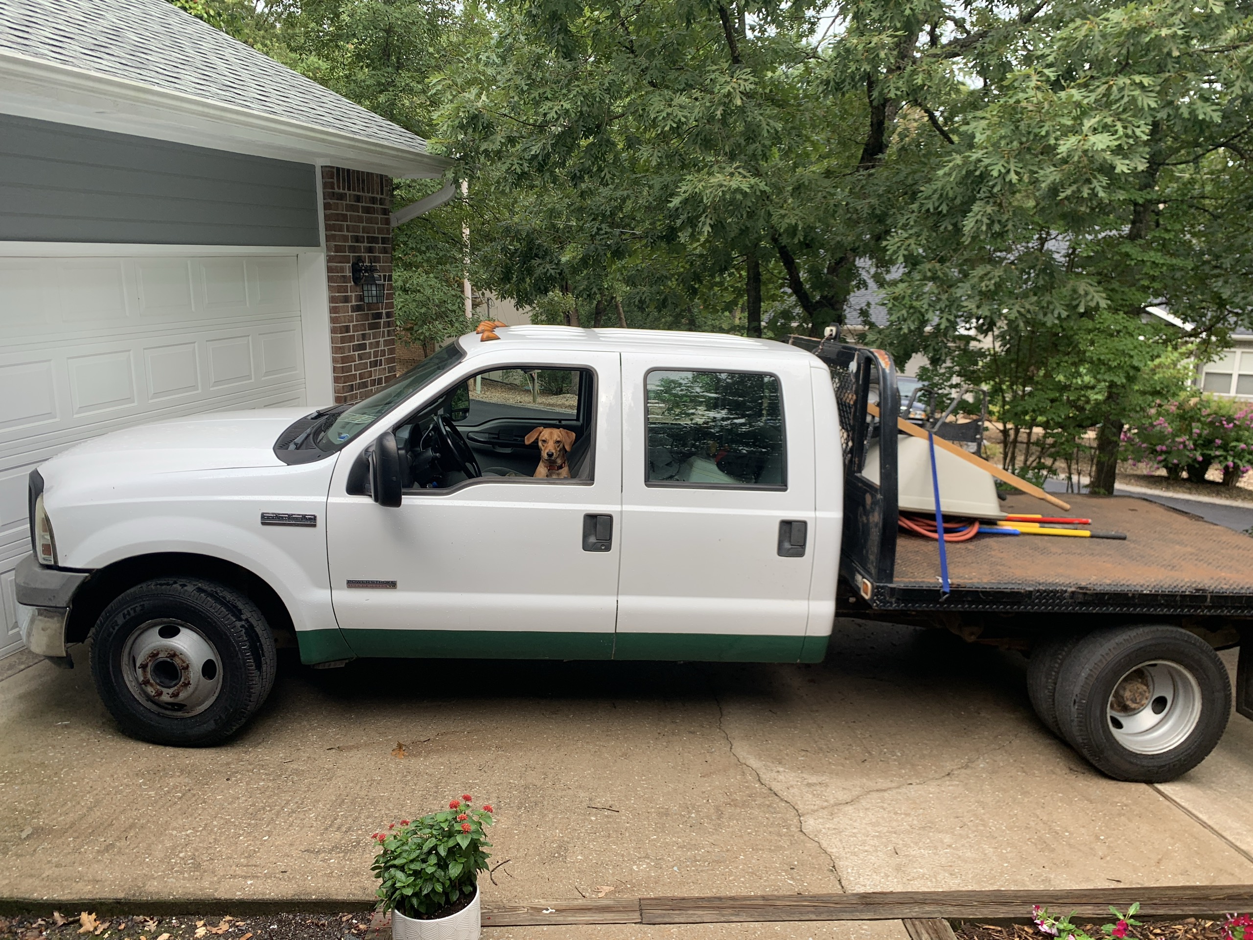 An older white diesel work truck loaded for a concrete job