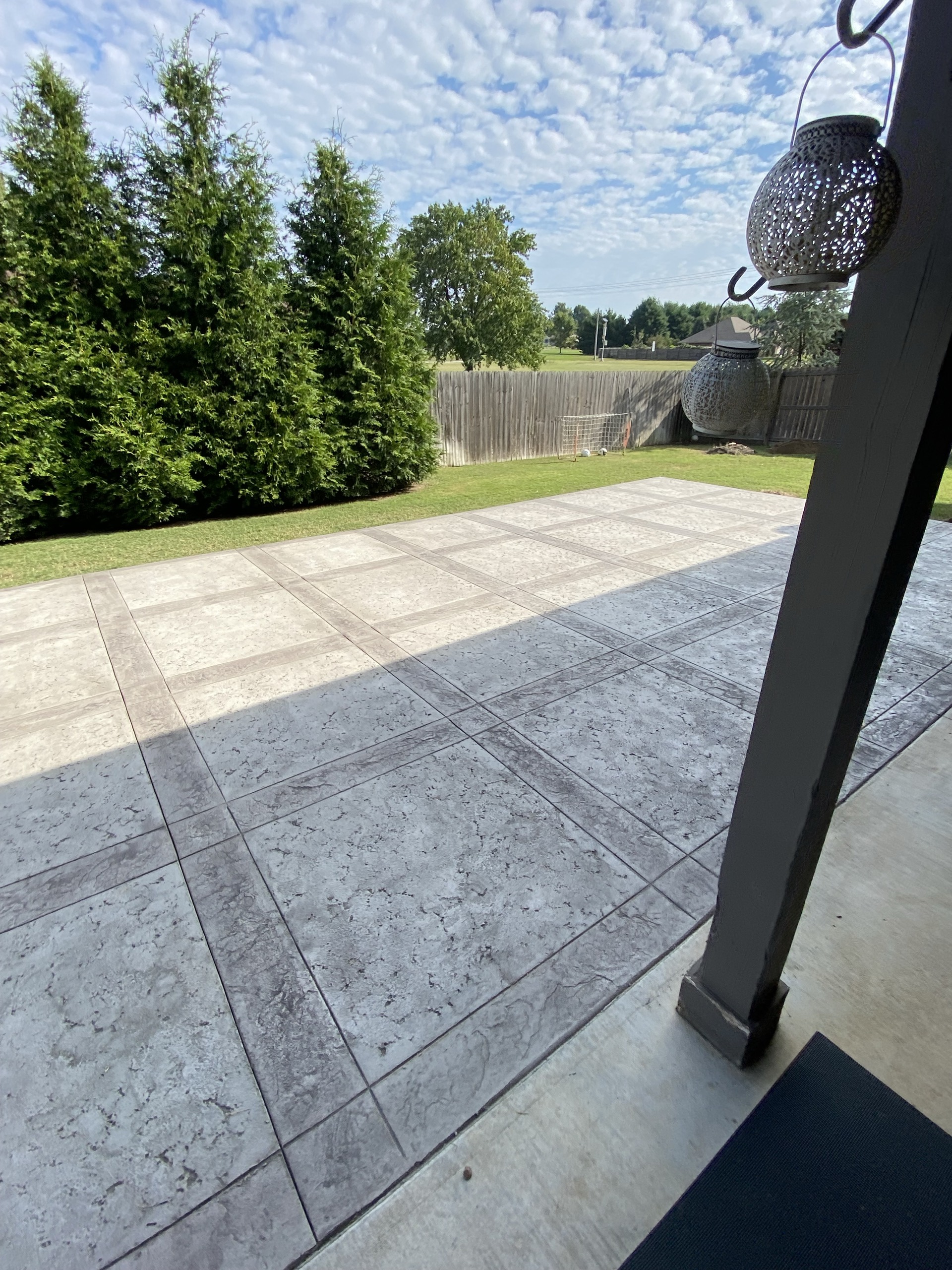 A finished gray stamped concrete patio beside a home